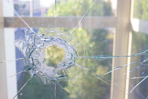 broken glass window reflecting blue sky. close up